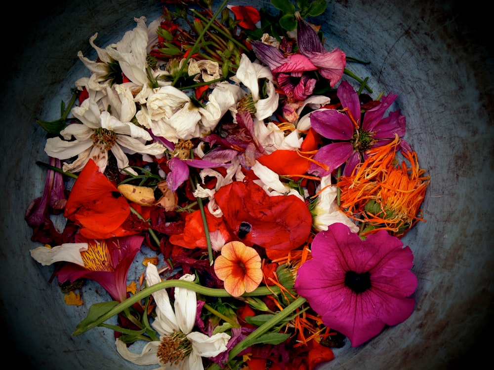 assorted flowers piled in container