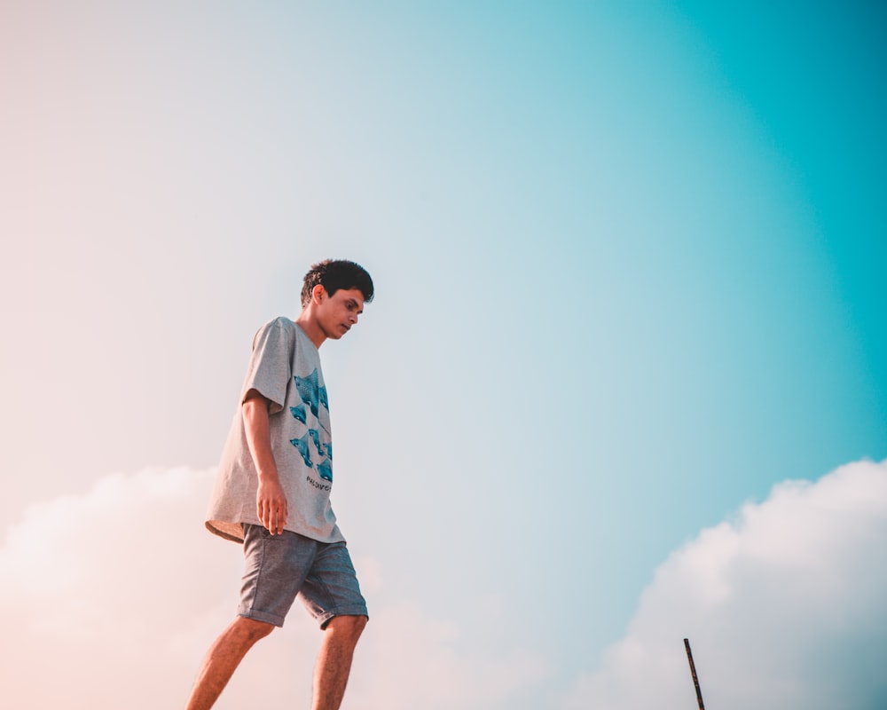 man in gray crew-neck shirt walking