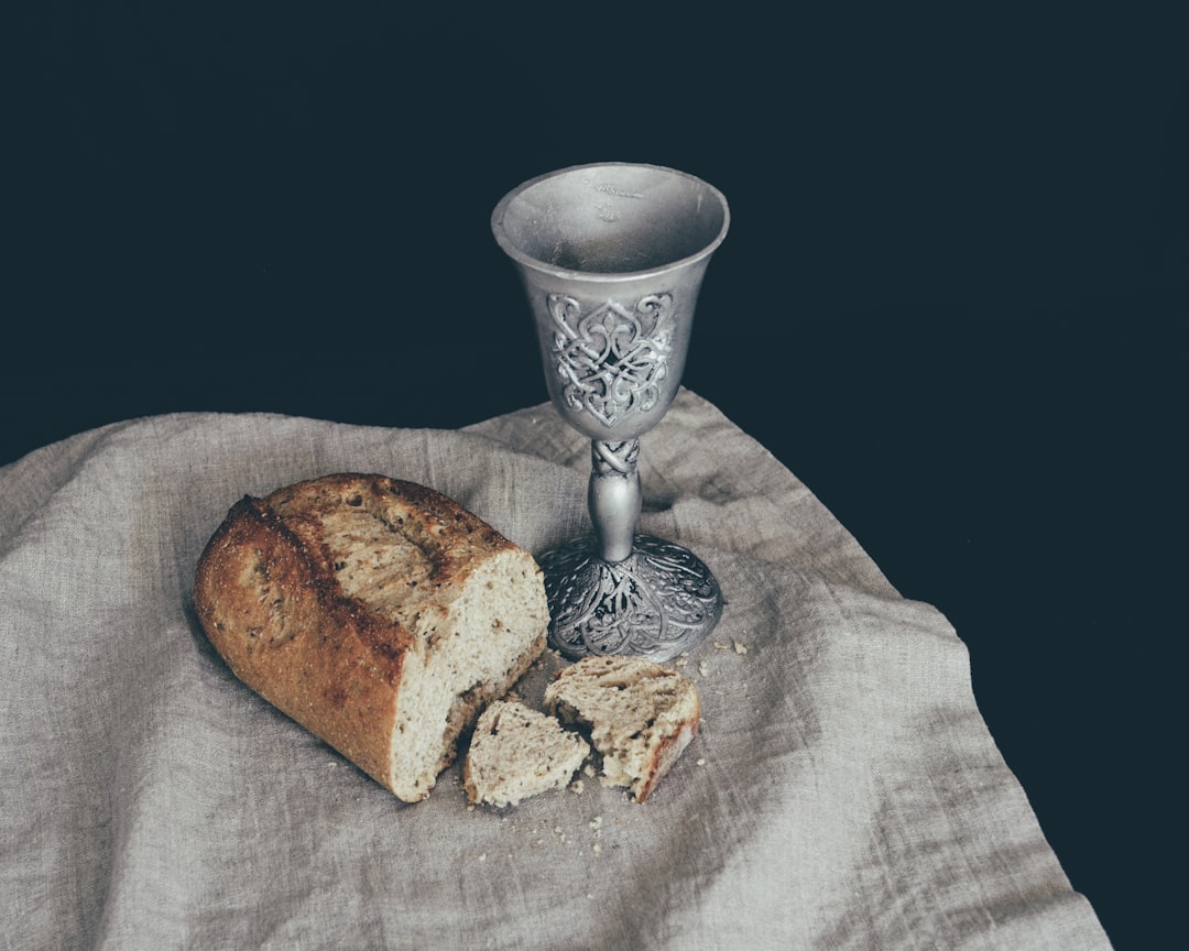 sliced of bread beside goblet, Symbols of religious communion. Many religions celebrate their faith with communion. Some