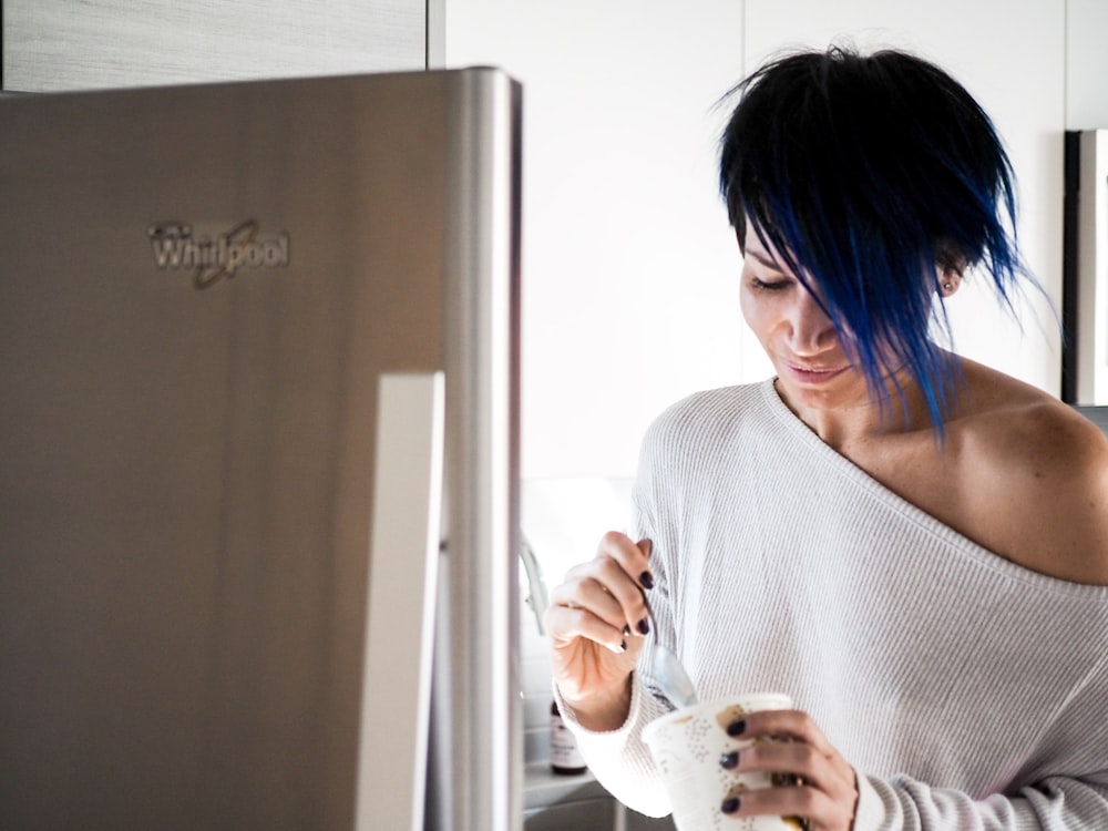 woman wearing white off-shoulder holding white cup