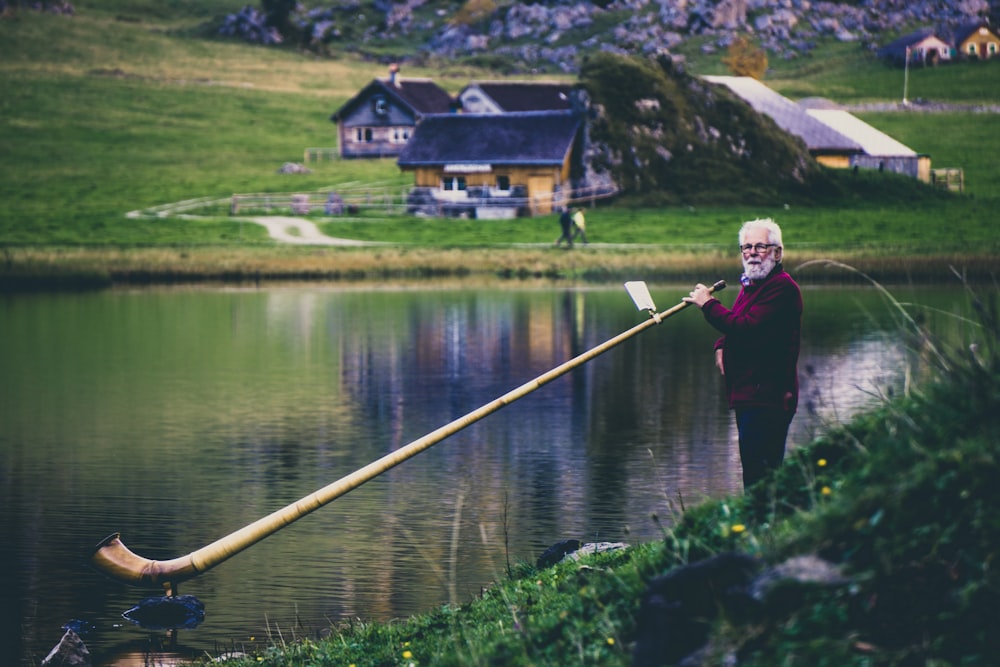mulher segurando instrumento de sopro alongado no lago