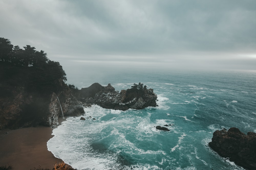 photo of ocean under cloudy sky