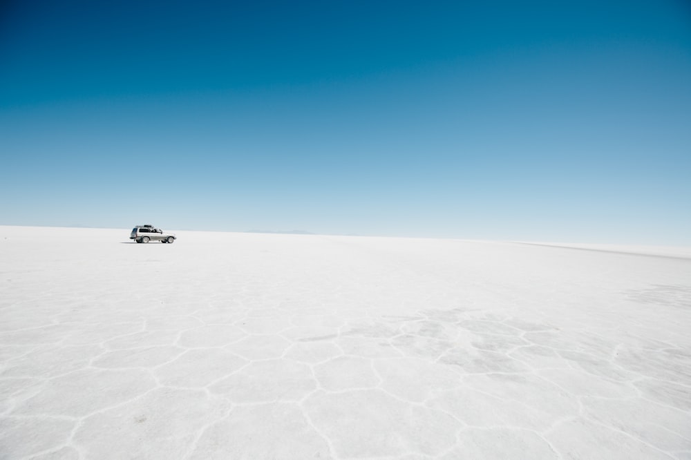 Auto d'argento sul marciapiede concreto sotto il cielo blu