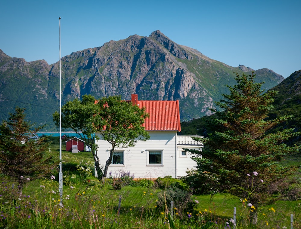 Weißes und rotes Betonhaus in der Nähe des Berges