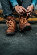 photography of person lacing his/her boots