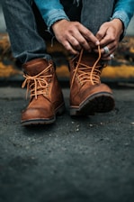 photography of person lacing his/her boots