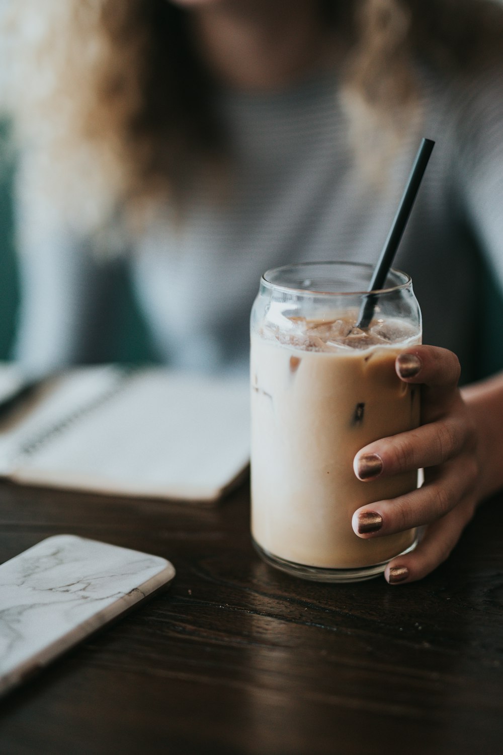 Mujer sosteniendo una taza de vidrio transparente