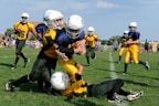 football players struggling to hold the football during daytime