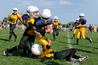football players struggling to hold the football during daytime