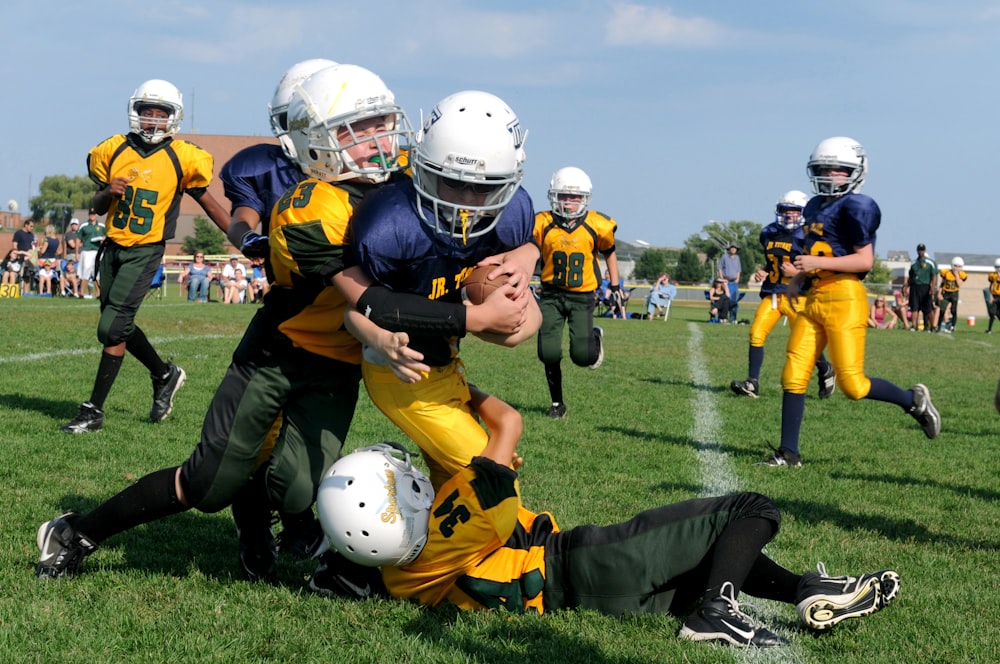 football players struggling to hold the football during daytime