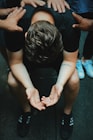 man sitting on chair holding and surrounded by people