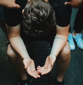 man sitting on chair holding and surrounded by people