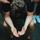 man sitting on chair holding and surrounded by people