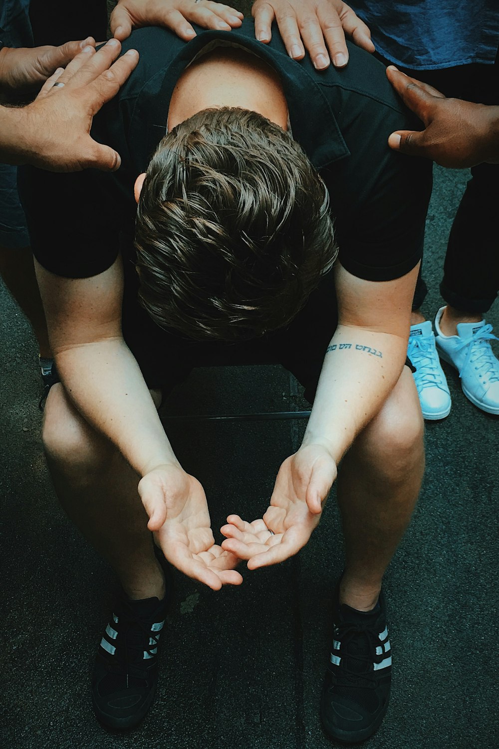 man sitting on chair holding and surrounded by people