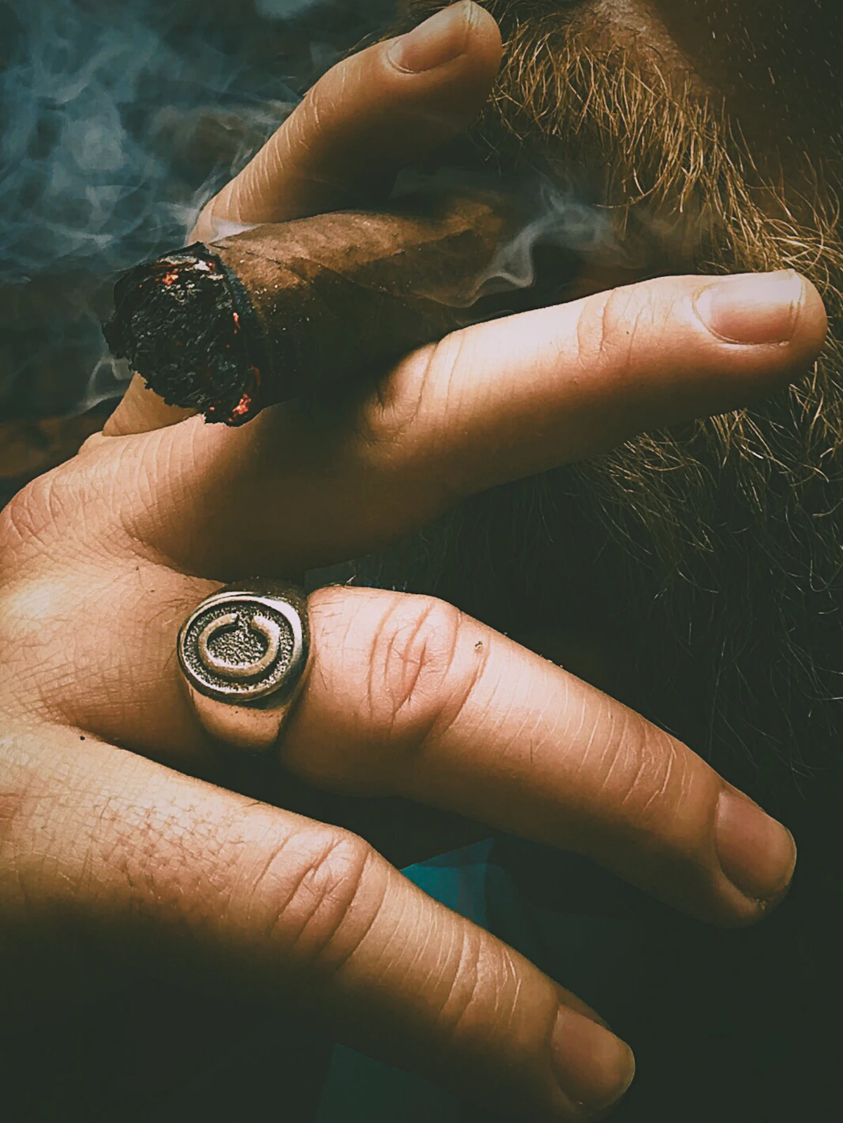 Cigar resting on a dark wooden surface with shallow shadows.