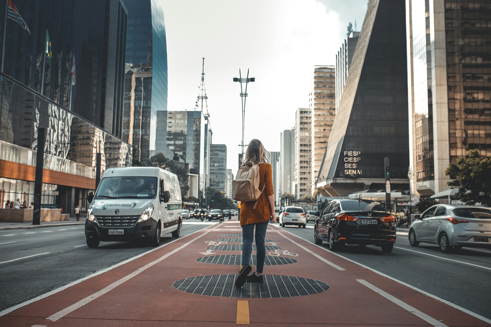 Woman walking up the middle of a downtown street.