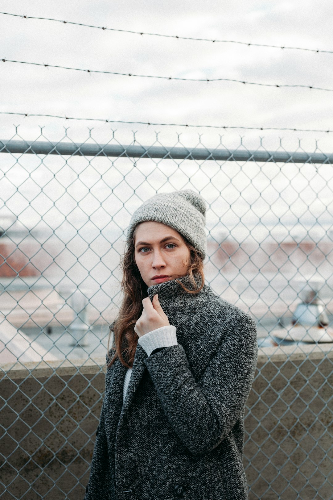 woman standing near gray steel chain link fence