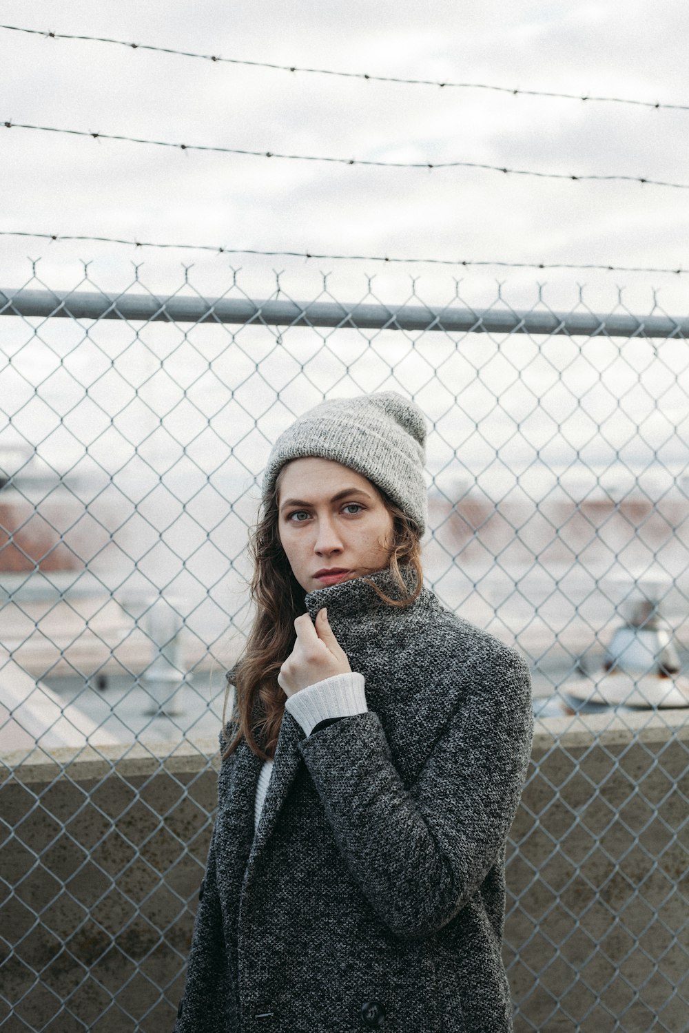 woman standing near gray steel chain link fence