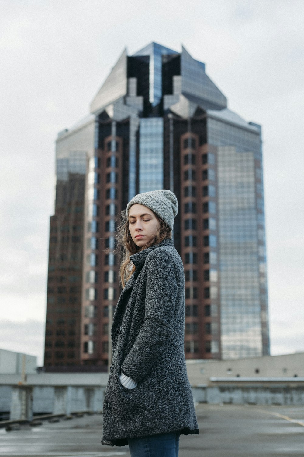 woman standing behind high rise building during daytime