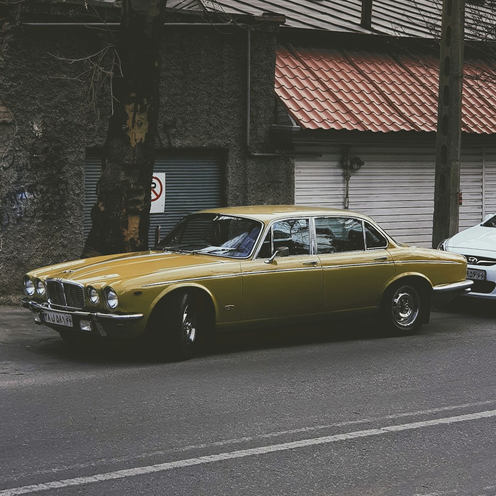 beige sedan on side of road during daytime