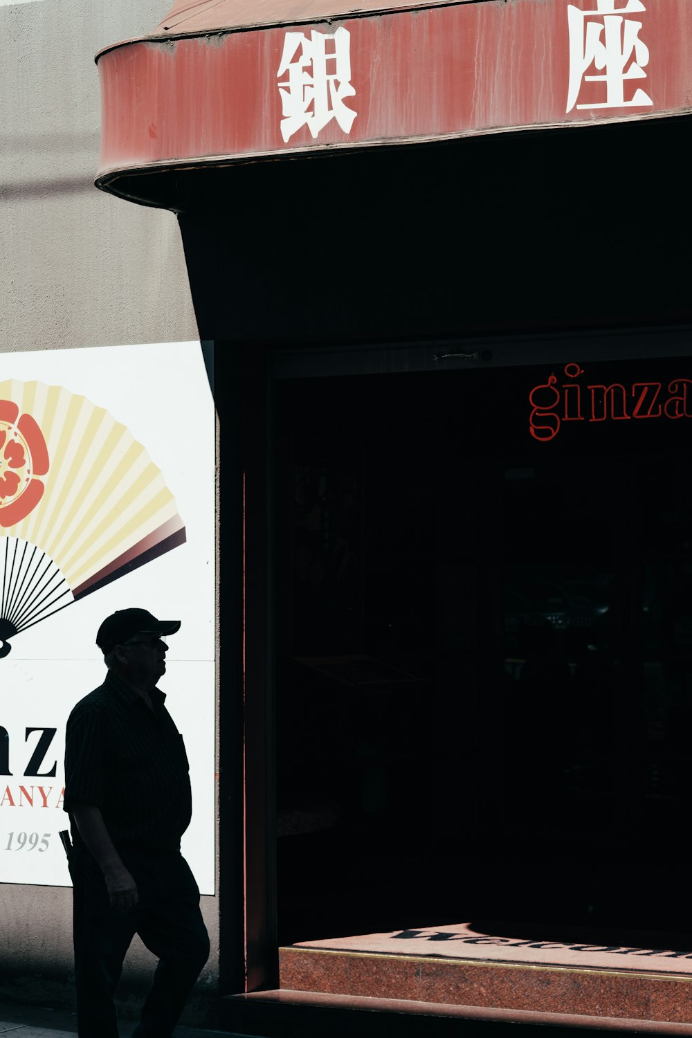 a man walking down a street past a store