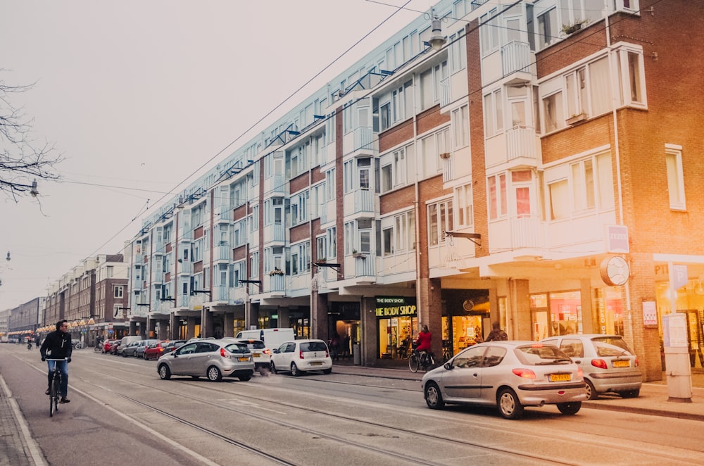 Fahrzeuge auf der Straße in der Nähe von braunen und grauen Gebäuden während des Tages