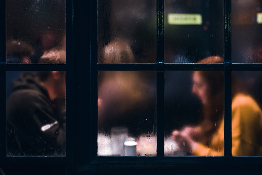 ventana empañada que muestra a dos personas sentadas