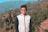 man in white full-zip jacket taking a photo on cliff