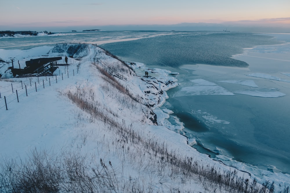 mountain covered with snow near large body of water during daytime view