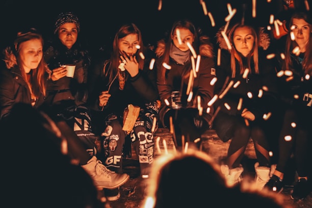 women near bonfire at night