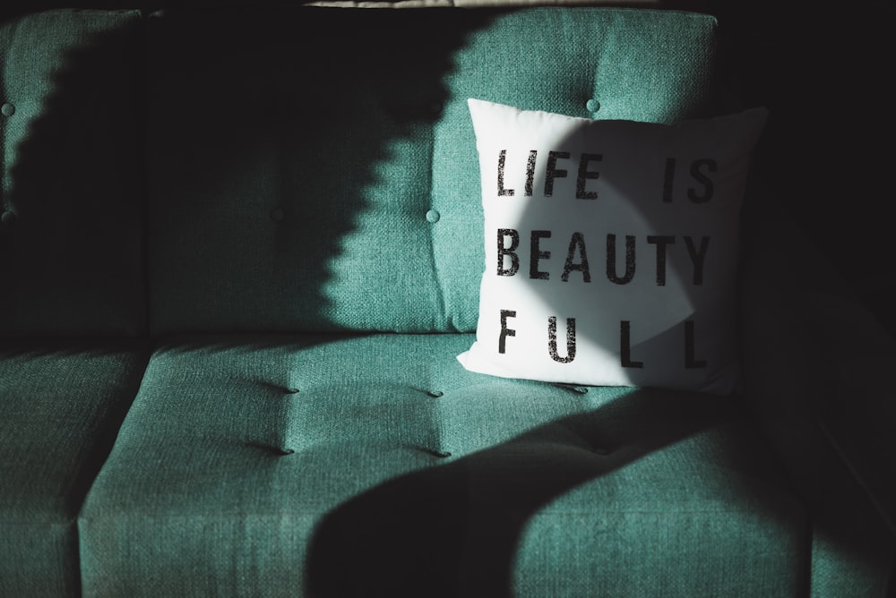 white and black Life is beautifull throw pillow on top of sofa