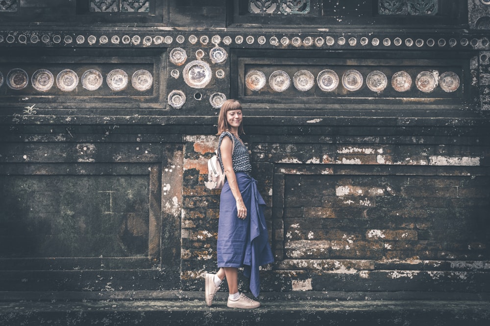 woman standing beside the wall