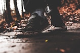 Close-up of trail running shoes on a forest path covered with leaves.