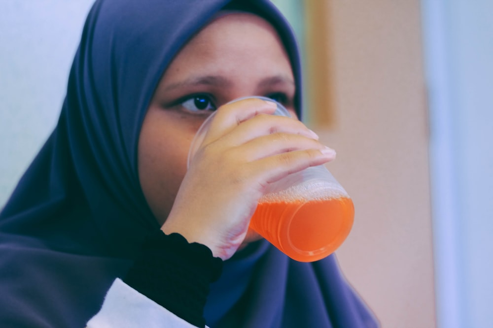 woman in black hijab headdress white drinking