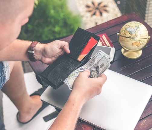 person holding wallet and US dollar bills