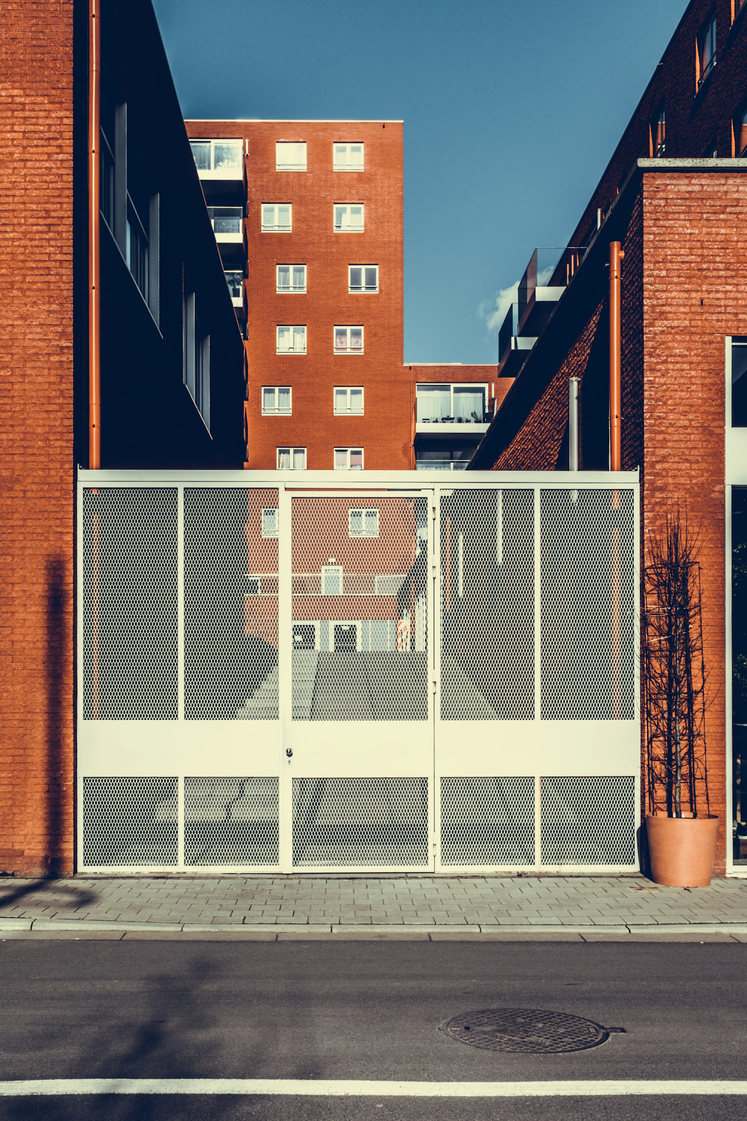 Referencia visual: puerta metálica blanca en una fachada de ladrillo