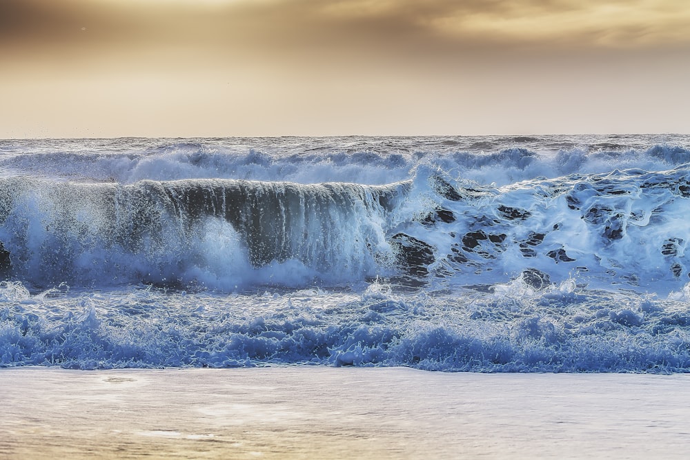 photo of sea waves under clear sky during daytime