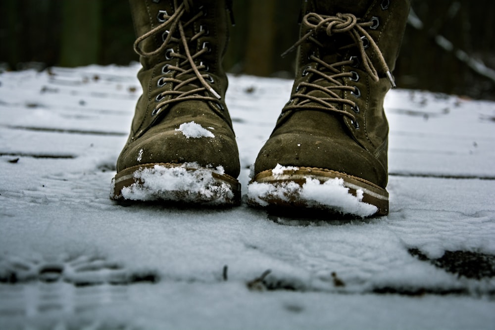 pair of brown leather boots on snow