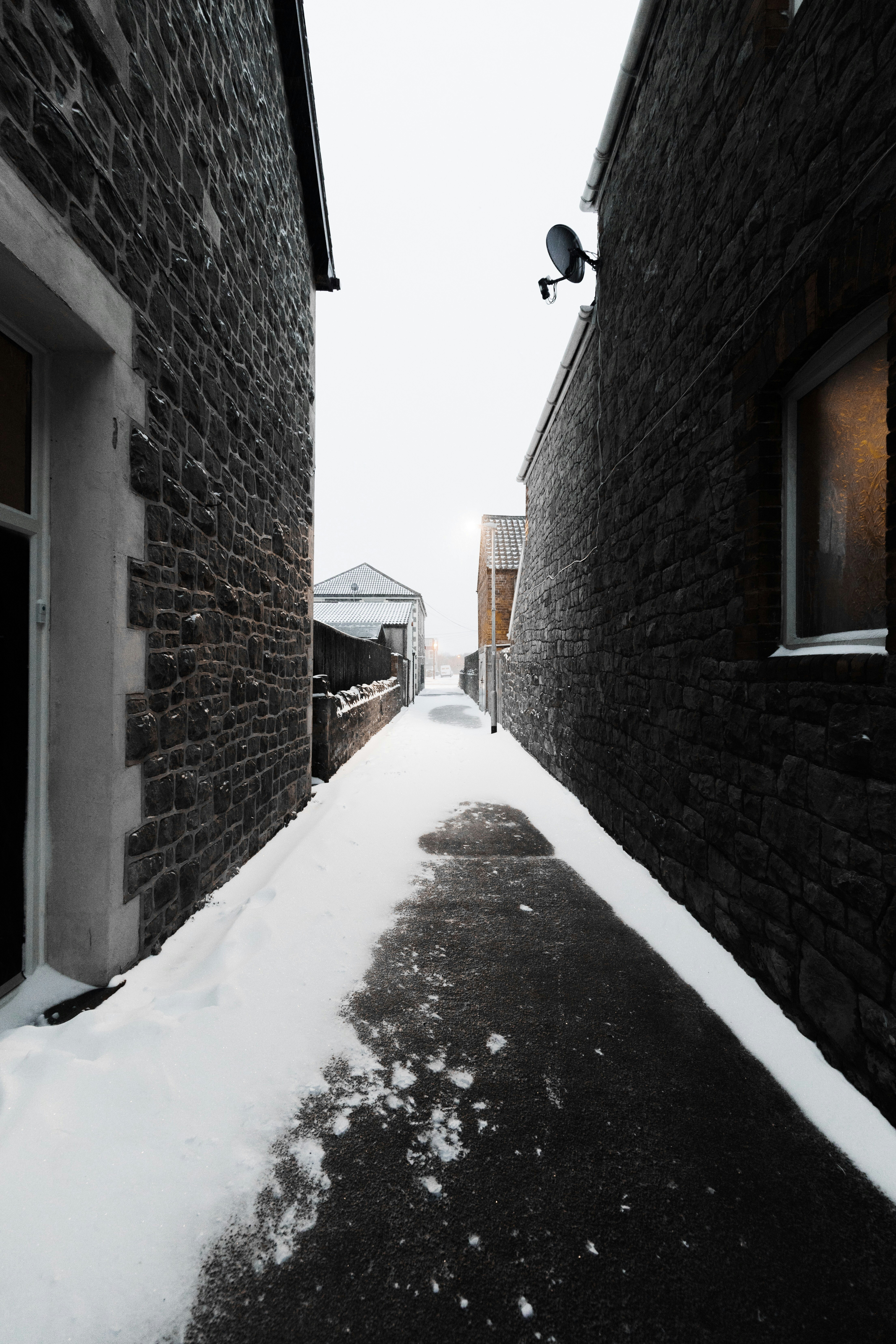 empty pathway in between the houses during daytime