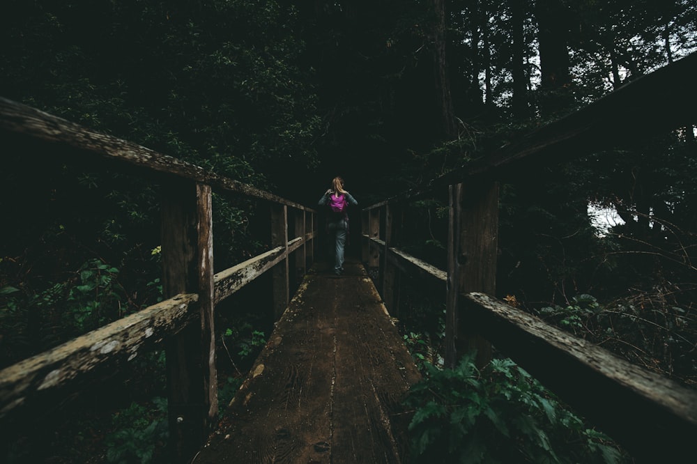 woman walking on wooden bridge