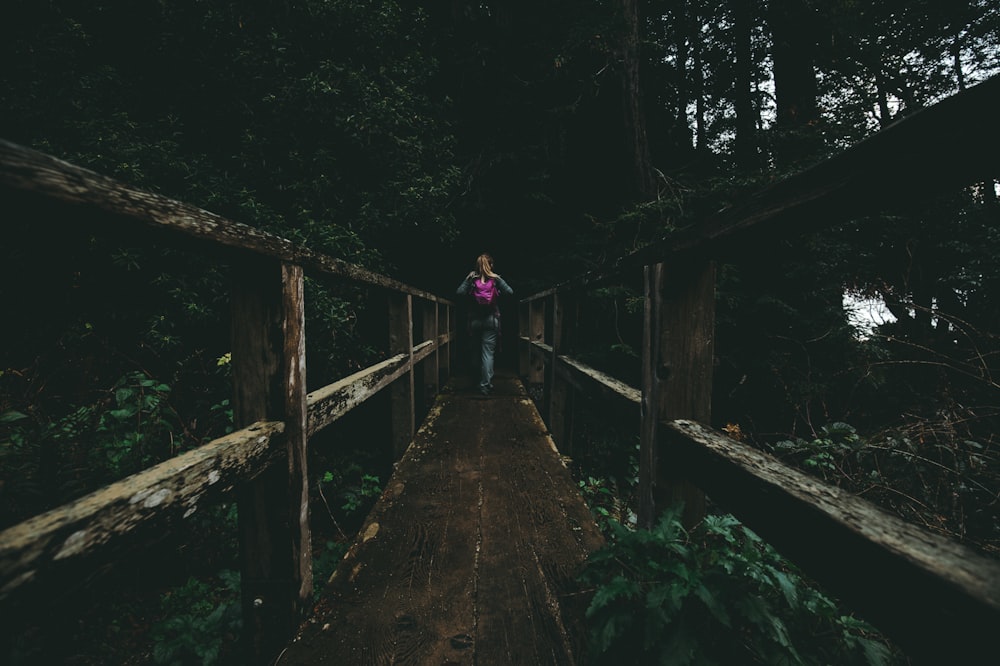 木の橋の上を歩く女性