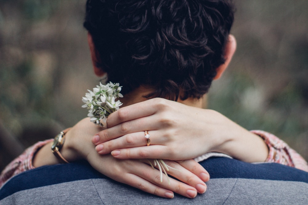 woman's hand on man's shoulder in close up photo