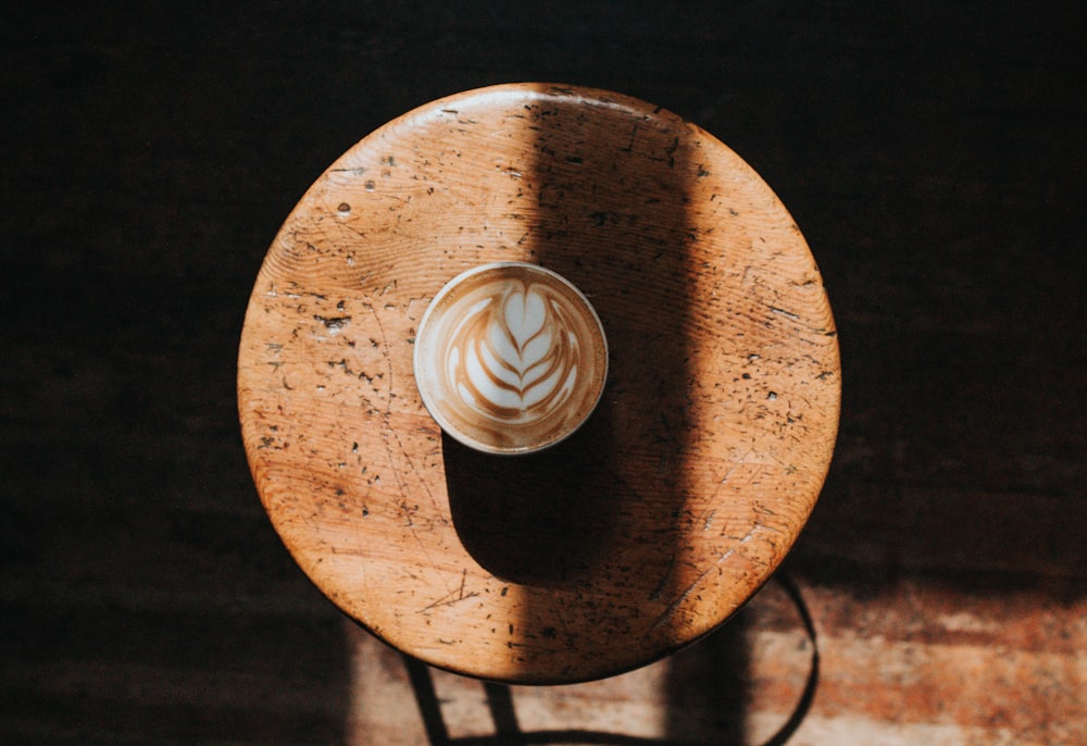 white ceramic cup on brown wooden stool