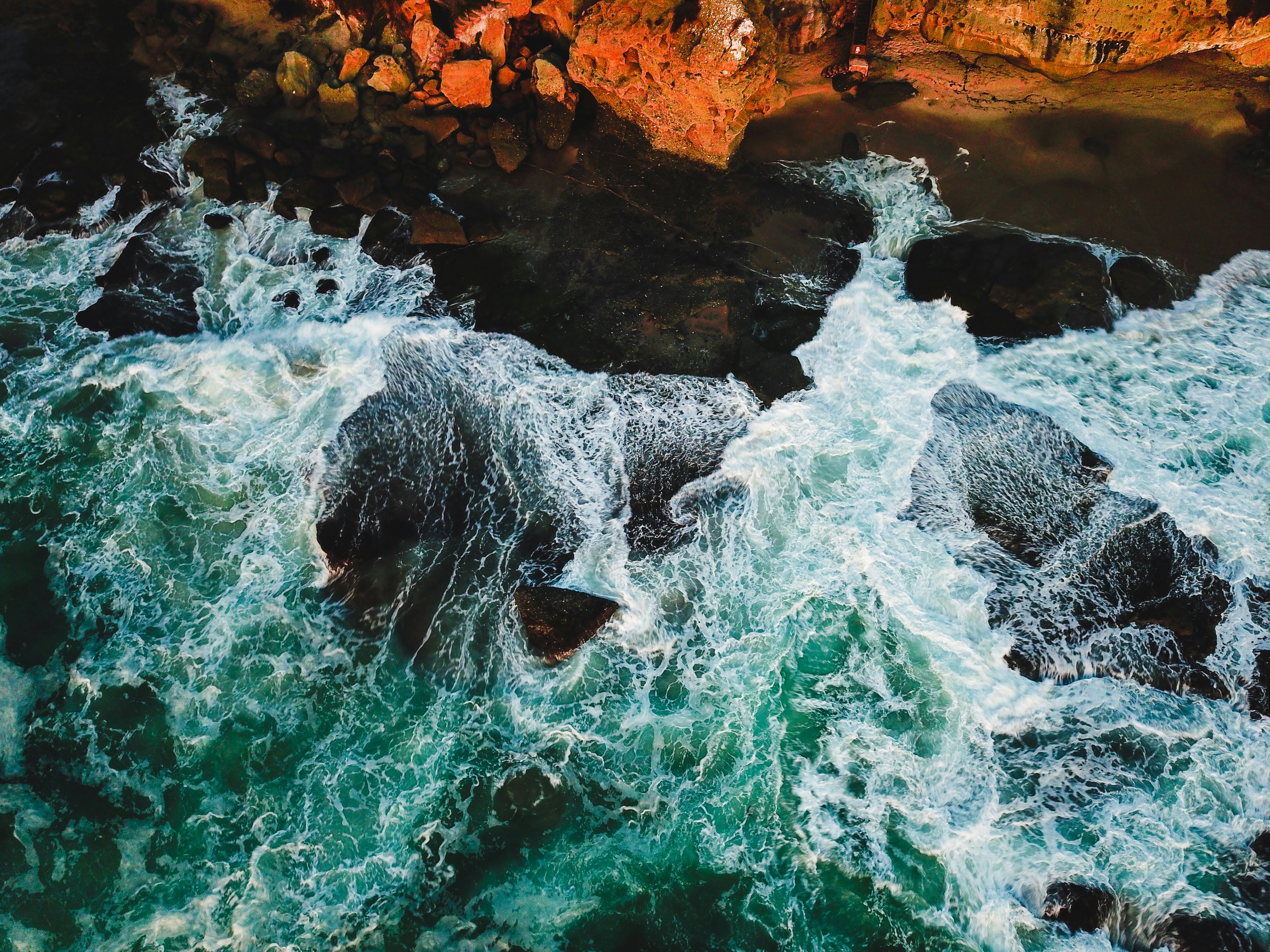 brown rock formation near the body of water photography