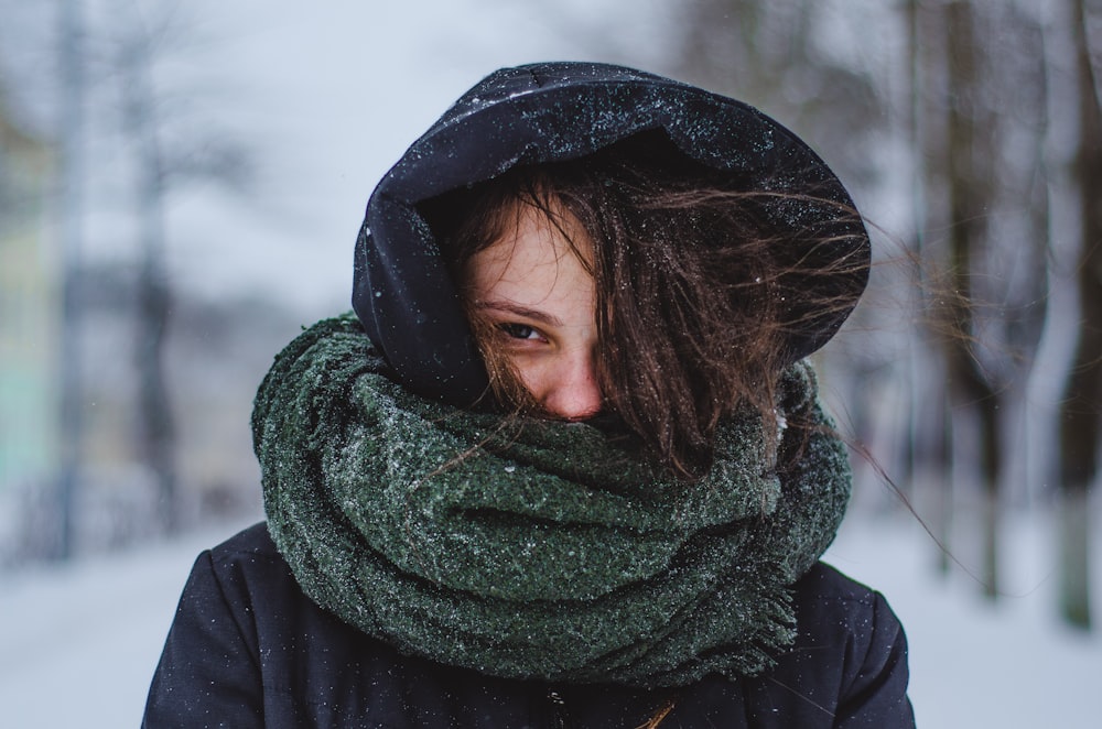 woman wearing hoodie under green scarf