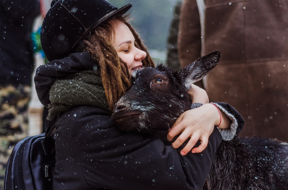 woman cuddling goat