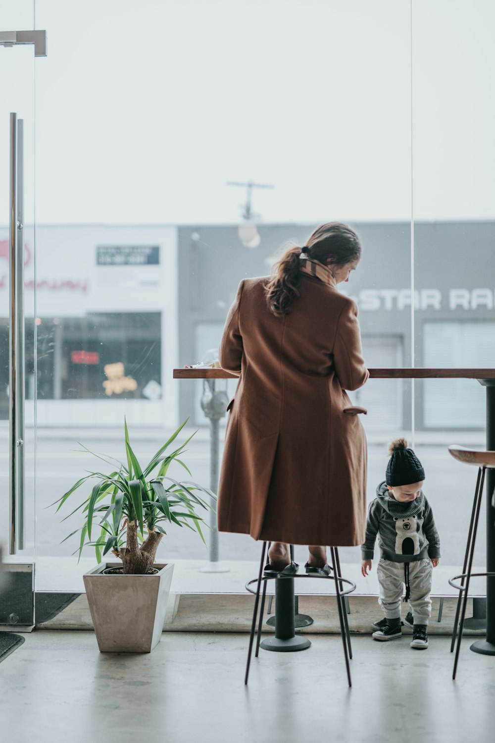 person sitting in stool looking at toddler