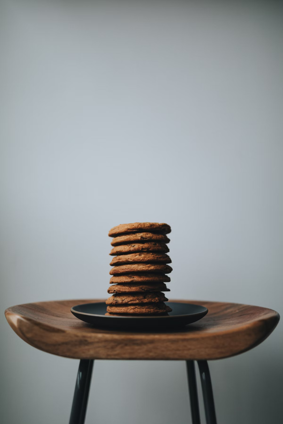 Stack of chocolate cookies on a black ceramic plate