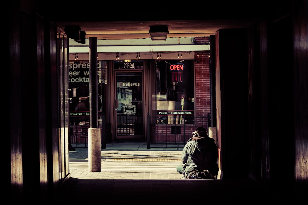 a person sitting on a bench in front of a store