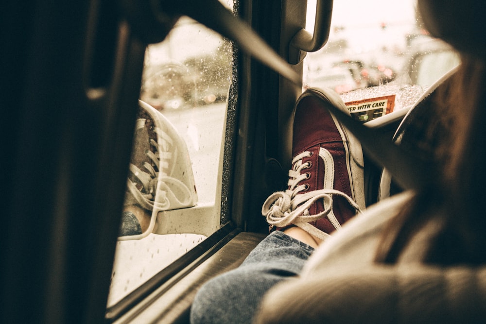 person raising foot beside vehicle steering wheel